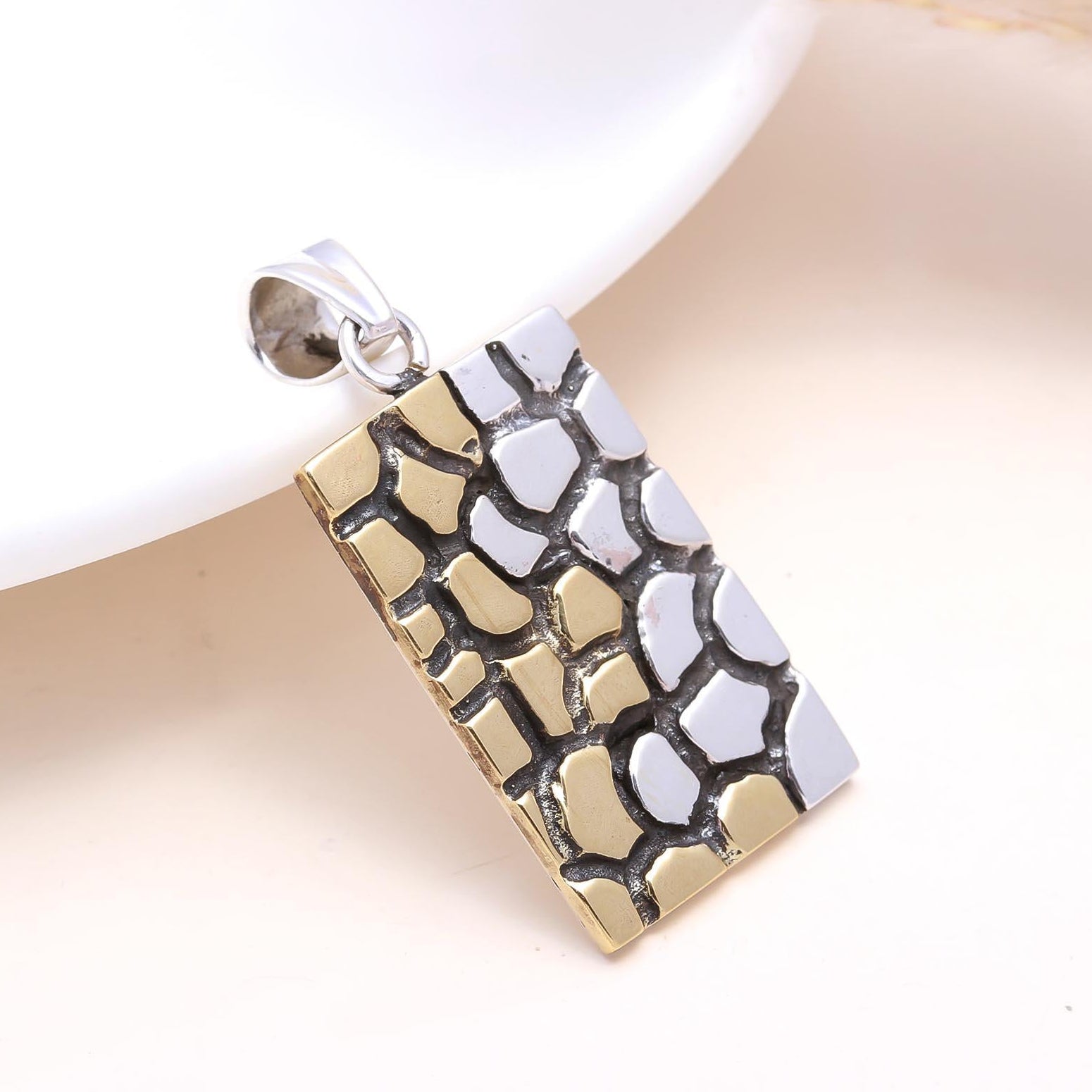 Gold and silver pendant on a white background