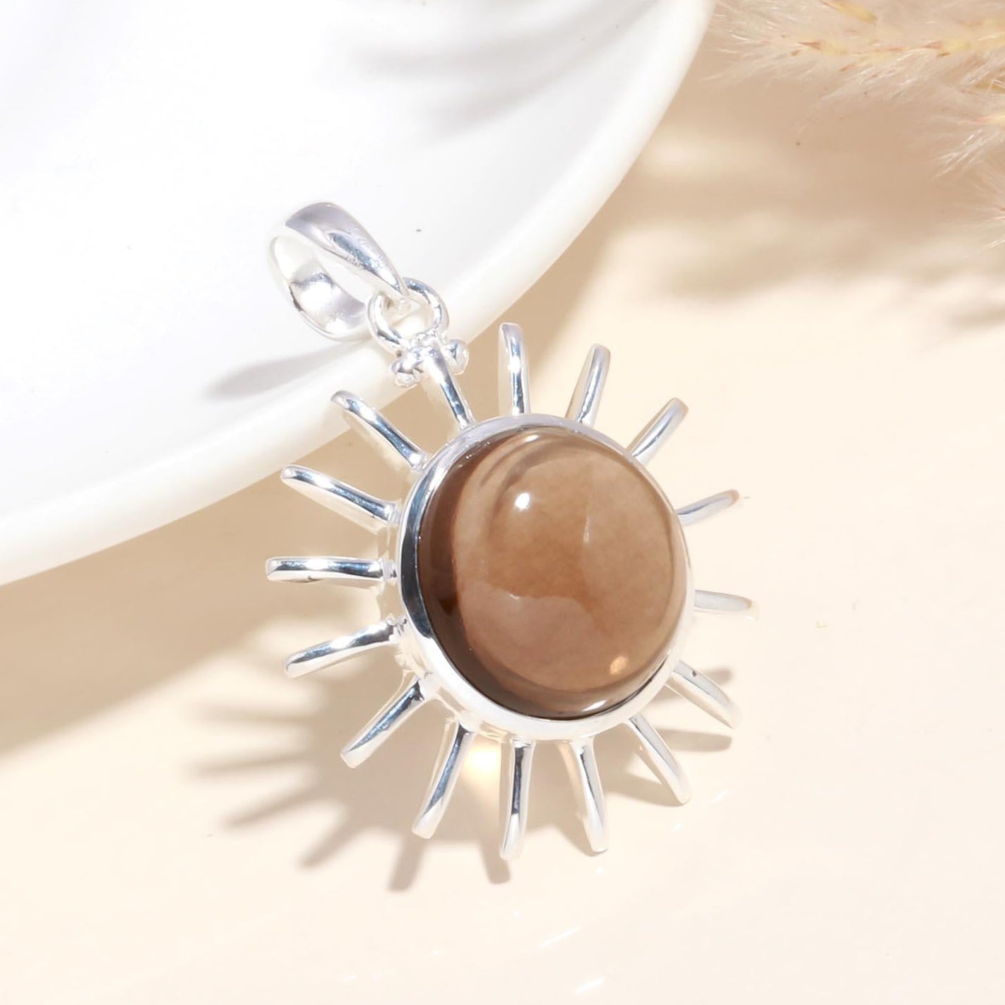A 925 Sterling Silver Sunburst Pendant with a brown gemstone at its center, displayed against a light background.