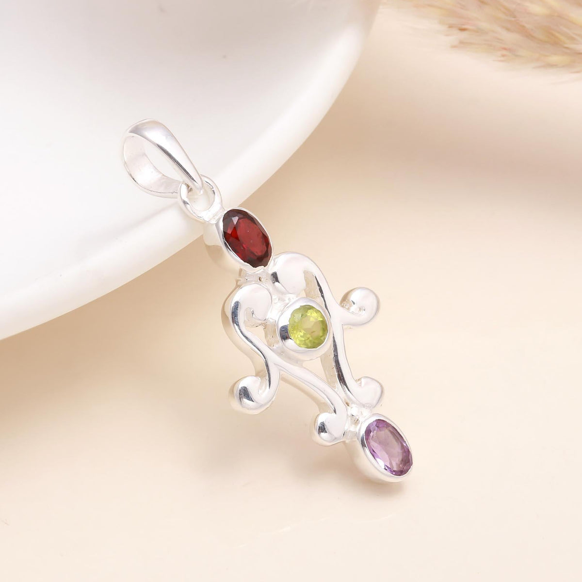 A 925 sterling silver vintage pendant featuring garnet, peridot, and amethyst gemstones on a white background.