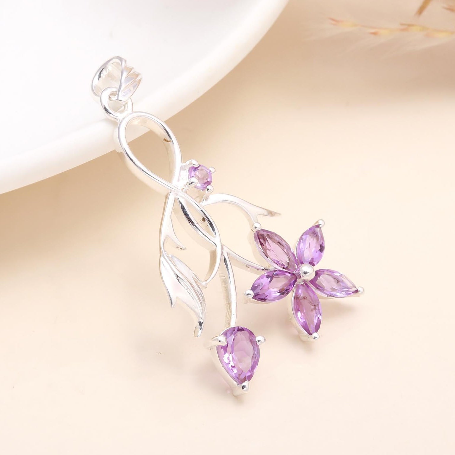 A 925 sterling silver pendant with a floral design, featuring natural amethyst gemstones.