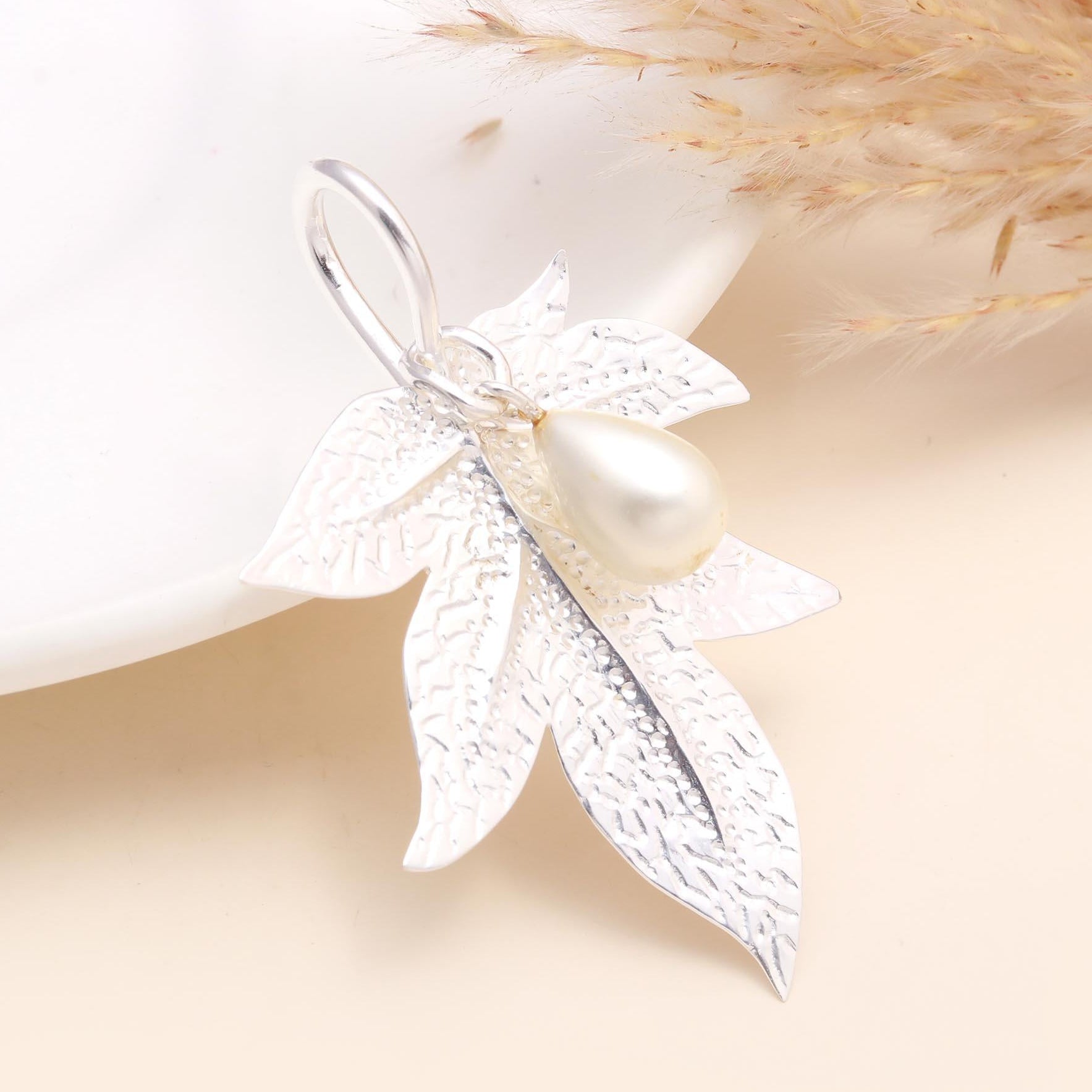 A 925 sterling silver textured leaf design pendant with a freshwater pearl centerpiece, displayed against a neutral background.