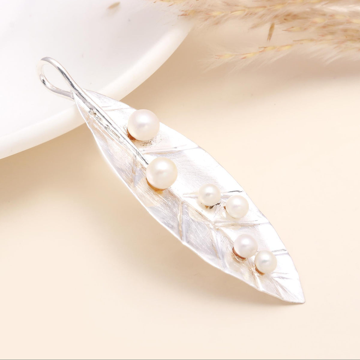 A 925 Sterling Silver Leaf Design Pearl Pendant displayed against a neutral background, featuring a silver leaf motif with freshwater pearls.