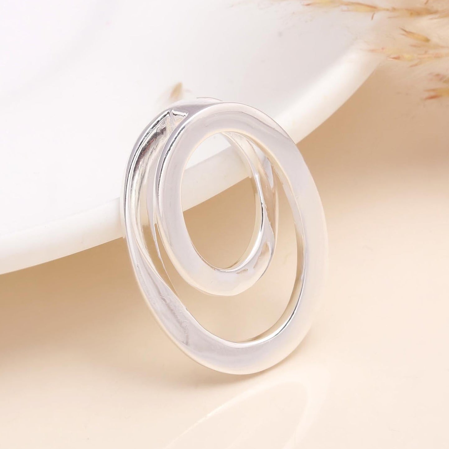 Silver ring on a soft beige surface with dried pampas grass