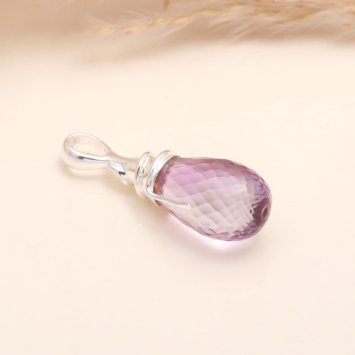 Purple teardrop pendant on a beige background