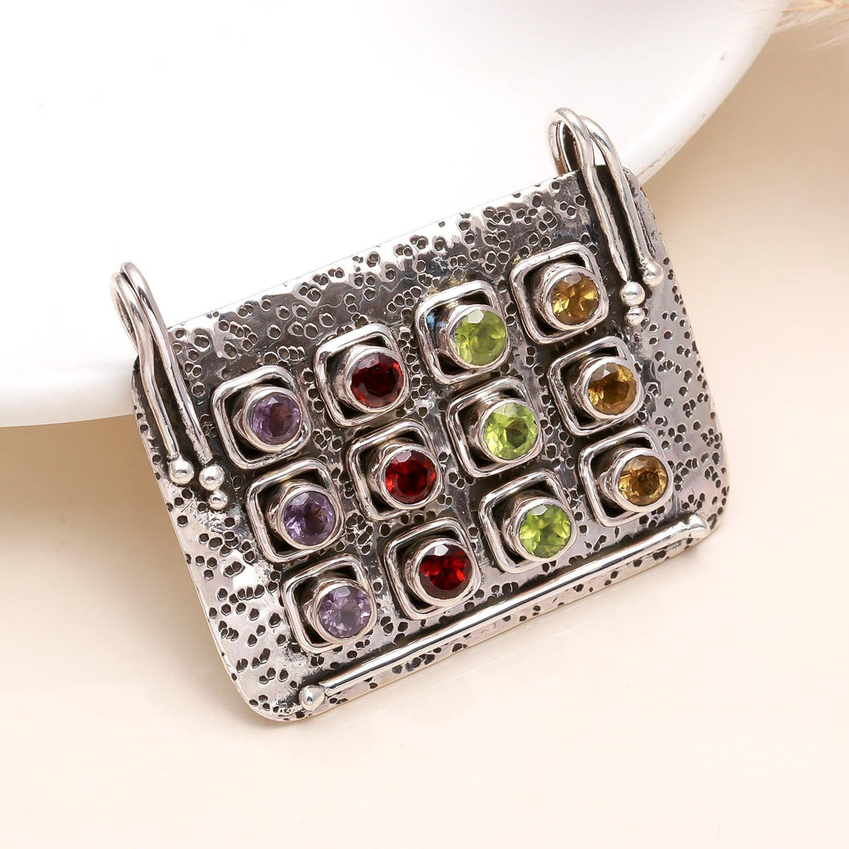 A rectangular 925 sterling silver pendant with multiple colored gemstones set within it. The pendant is displayed against a neutral background.