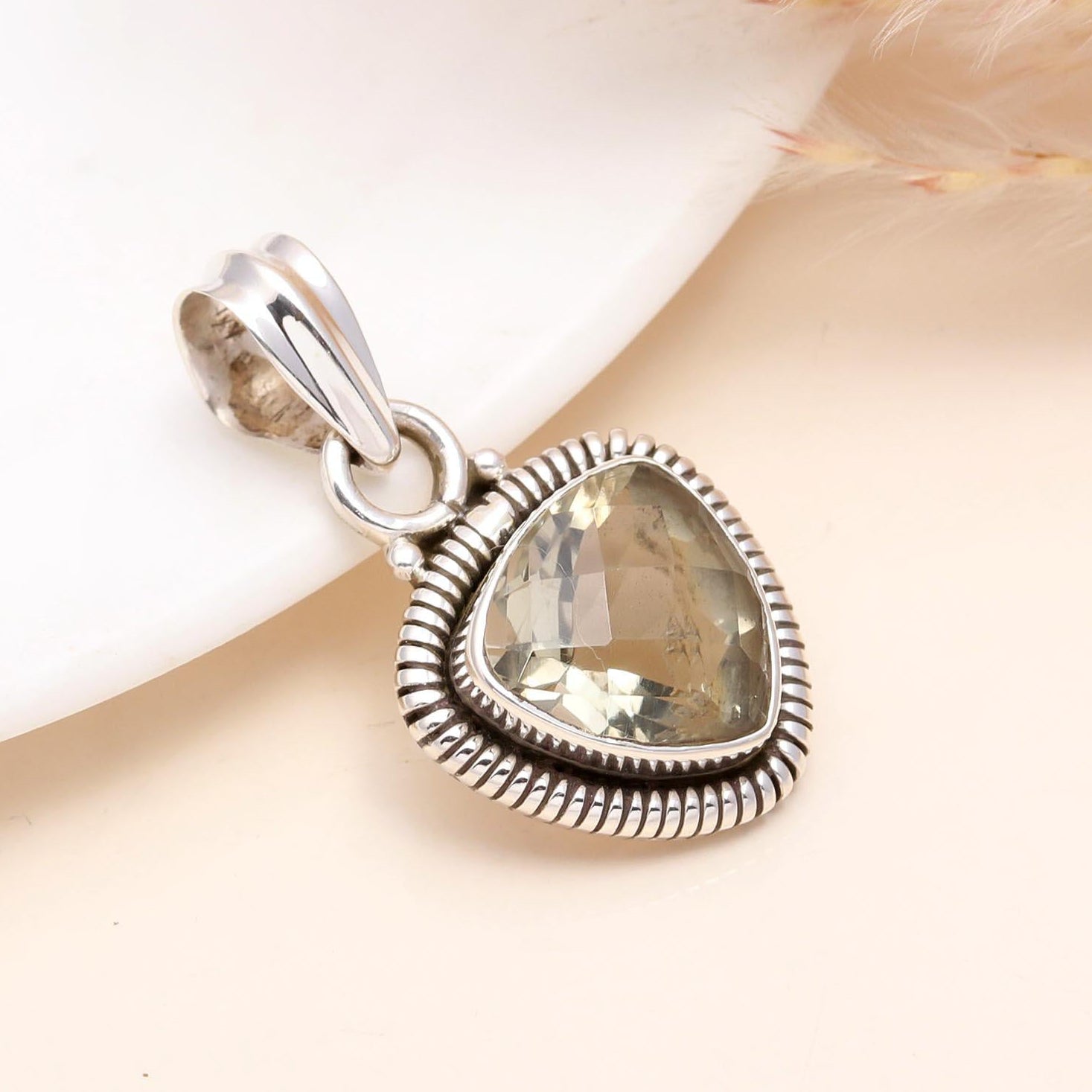 A trillion-cut lemon quartz gemstone pendant set in a sterling silver boho-style setting, displayed against a neutral background.