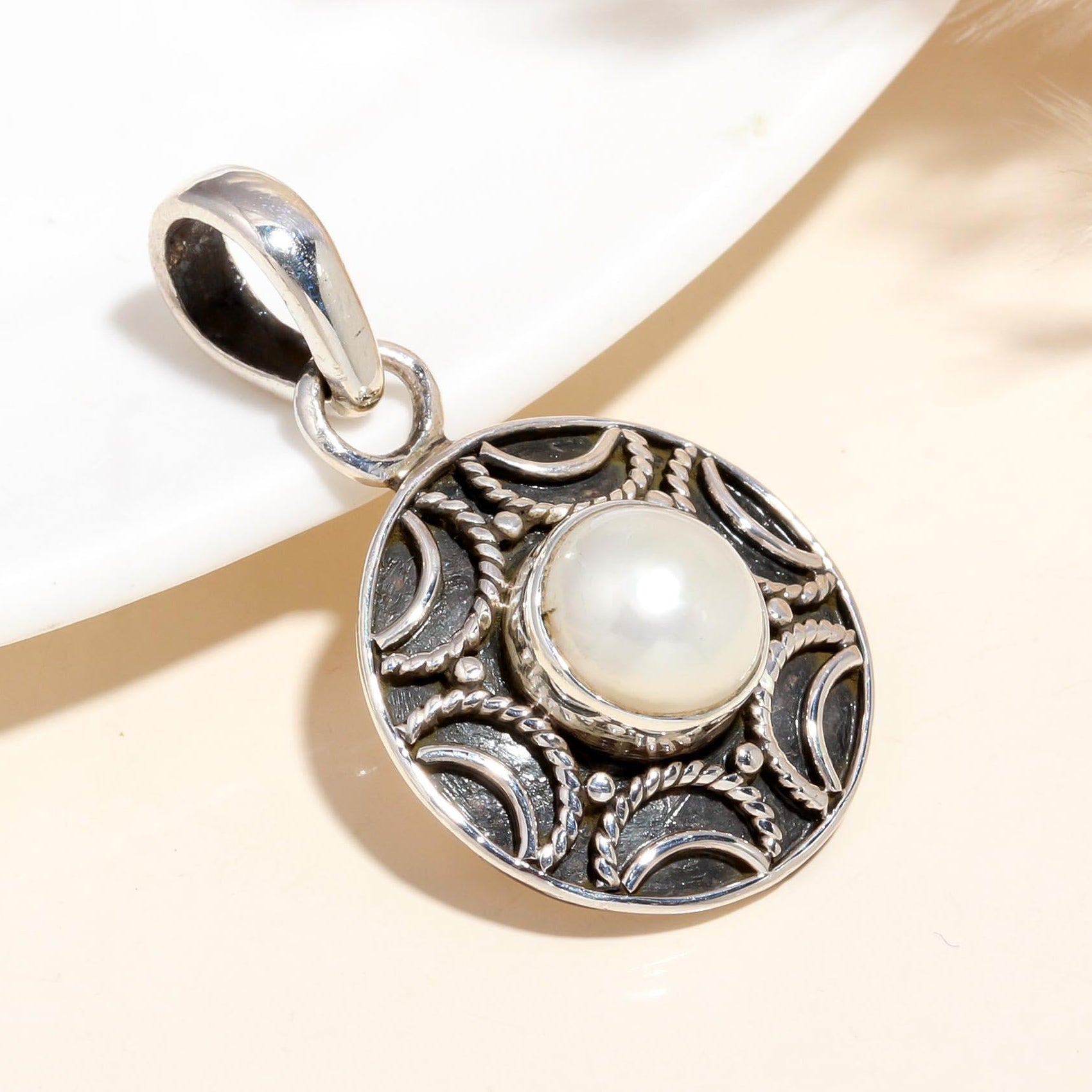 A vintage-inspired 925 sterling silver pendant featuring a central pearl, surrounded by intricate filigree detailing.