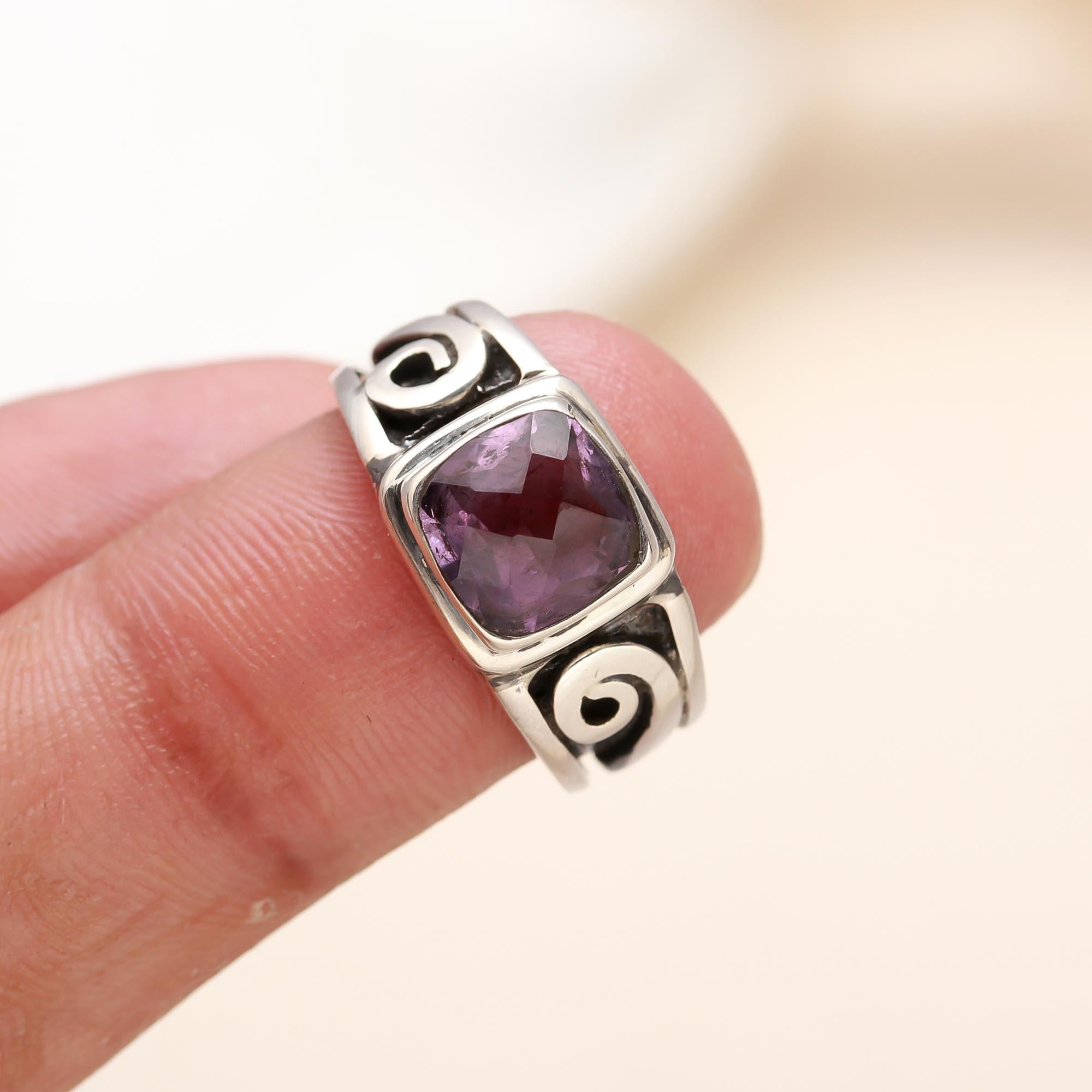 Close-up of cushion-cut amethyst with elegant swirl silver band