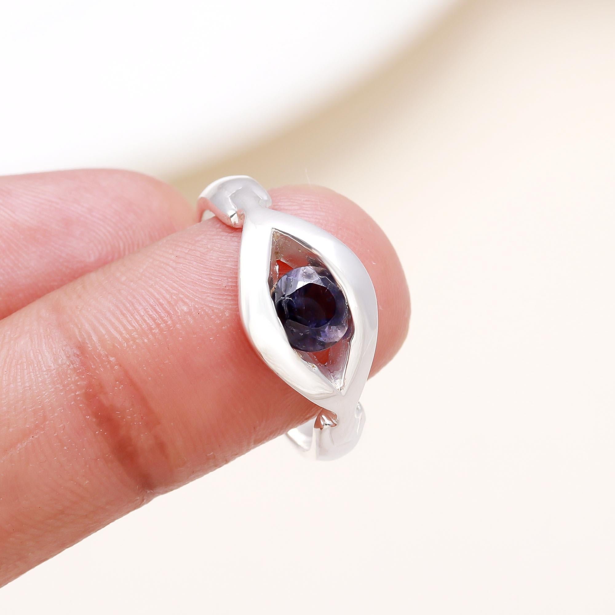 Round-cut iolite ring displayed on finger