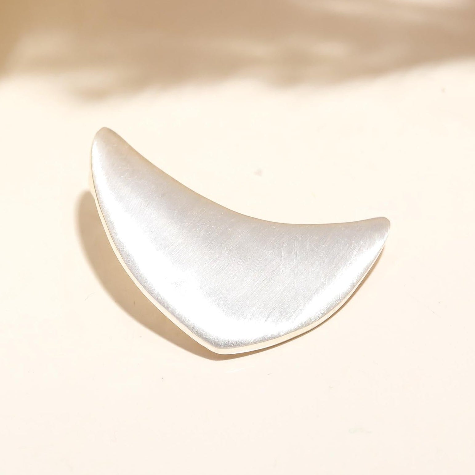 White ceramic crescent moon dish on a beige background