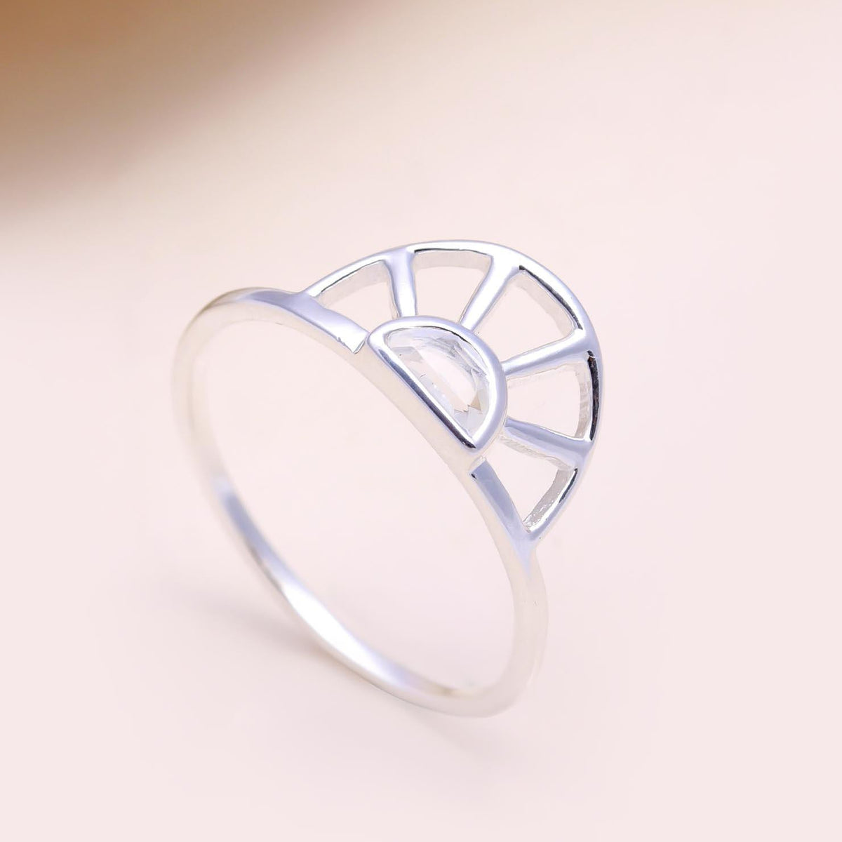 Silver ring with a unique design on a light pink background