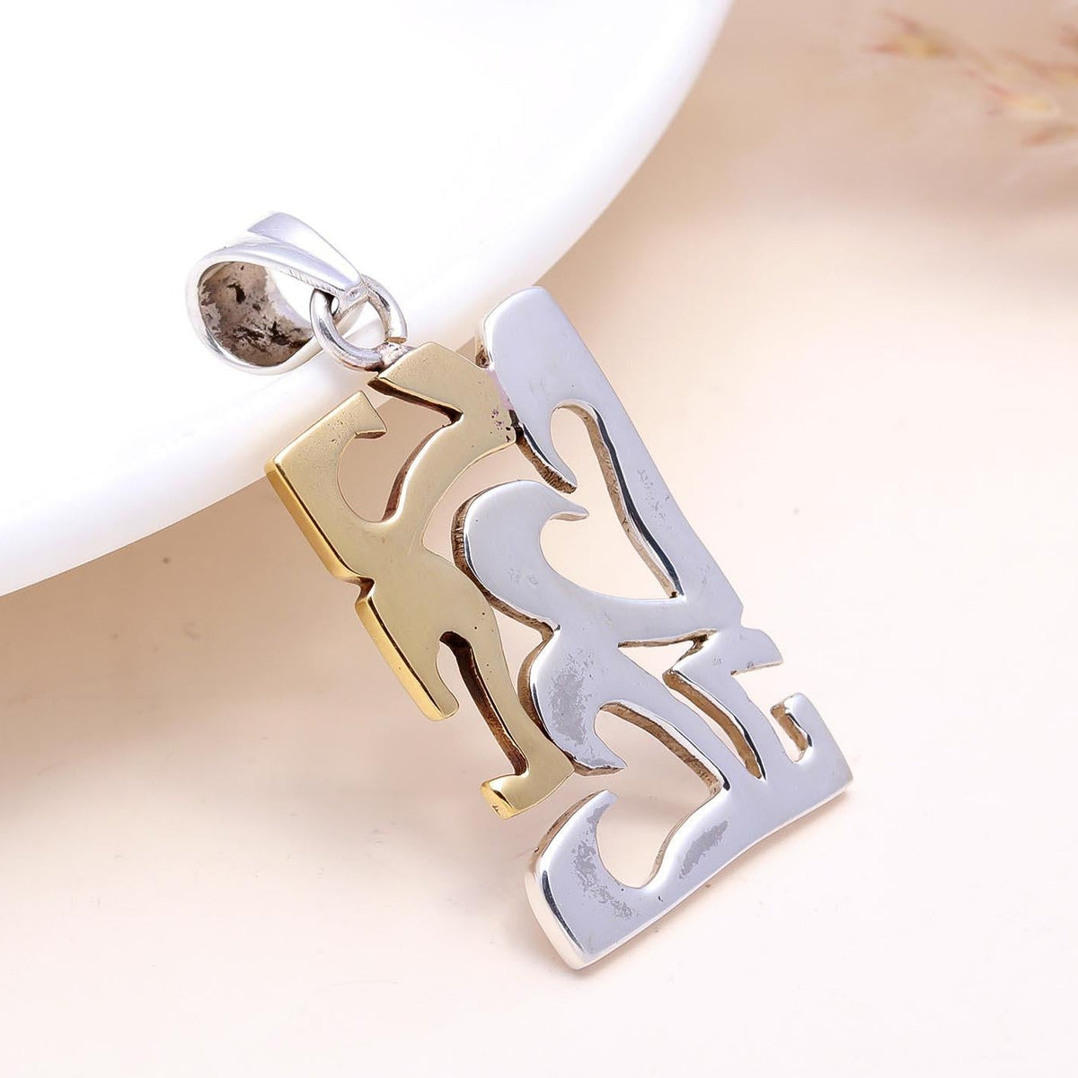 Gold and silver pendant on a white background