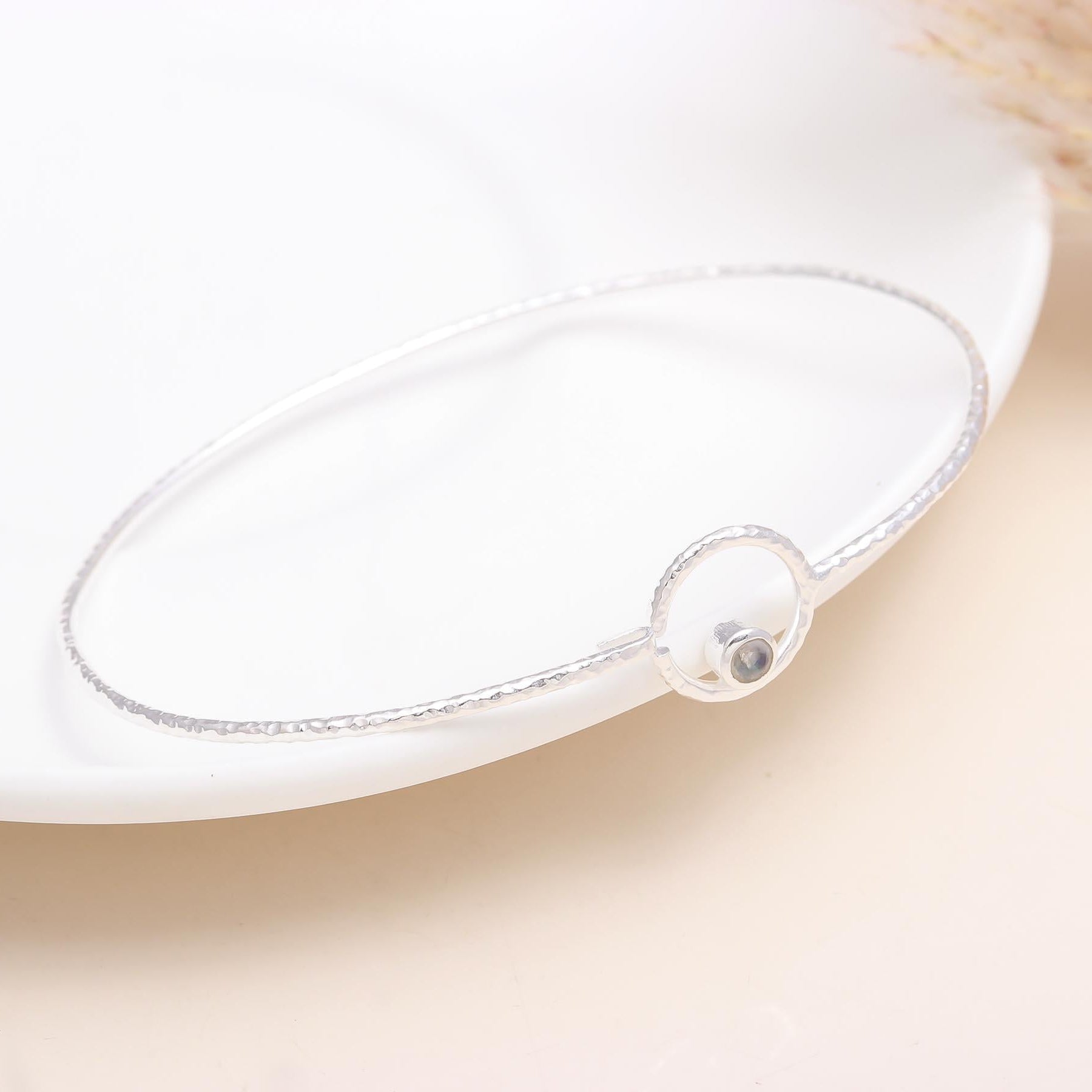 A 925 sterling silver hammered circle bangle bracelet displayed on a white surface.