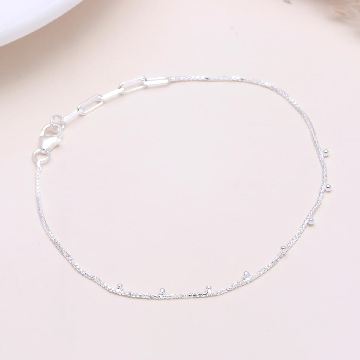 A 925 sterling silver satellite chain bracelet with satellite beads spaced along a fine chain, displayed against a light background.
