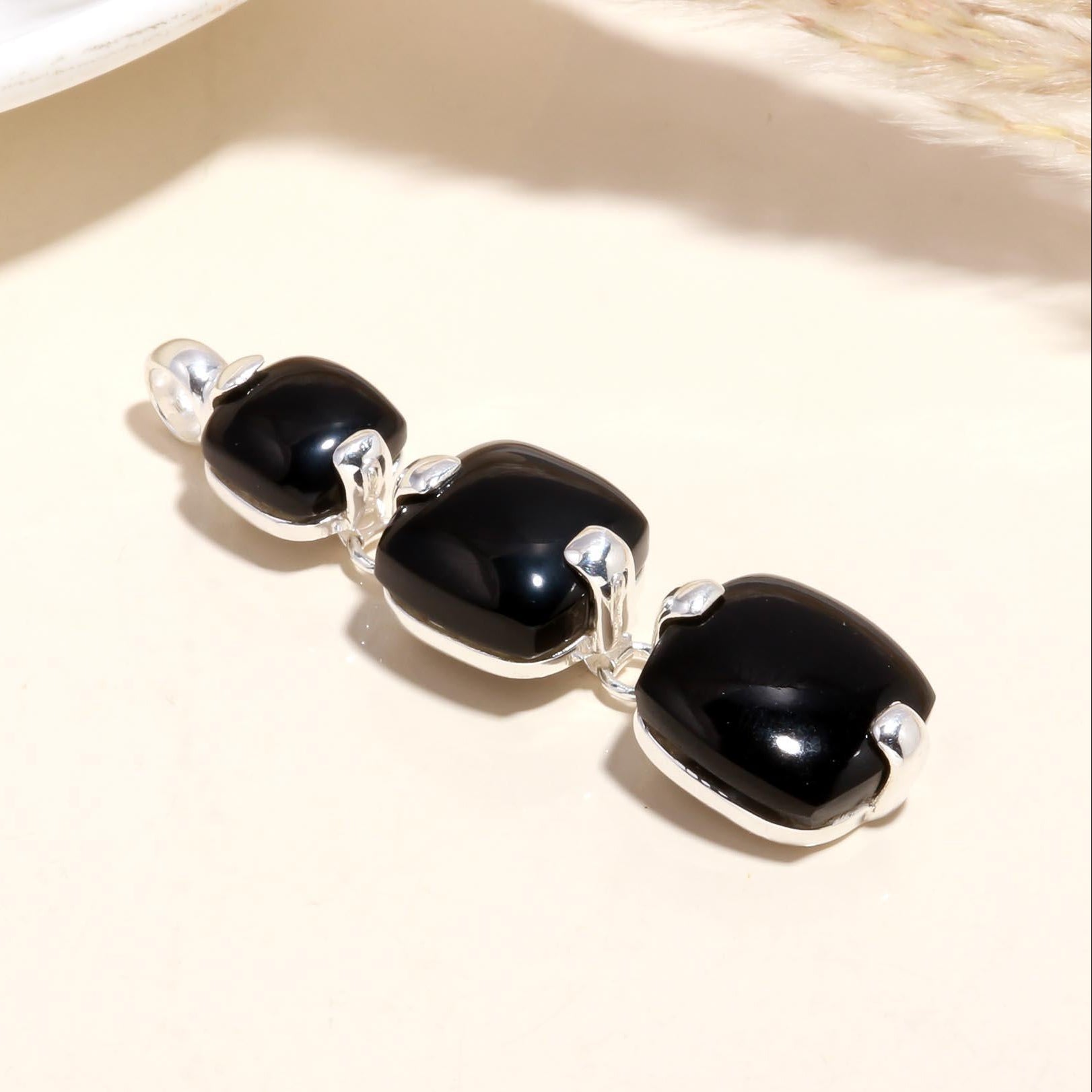 A 925 Sterling Silver Triple Black Onyx Pendant with three black onyx gemstones arranged in a cascading drop design, set against a neutral background.