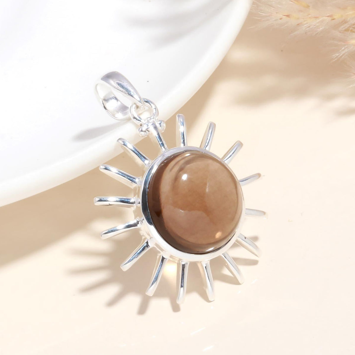 A 925 Sterling Silver Sunburst Pendant with a brown gemstone at its center, displayed against a light background.
