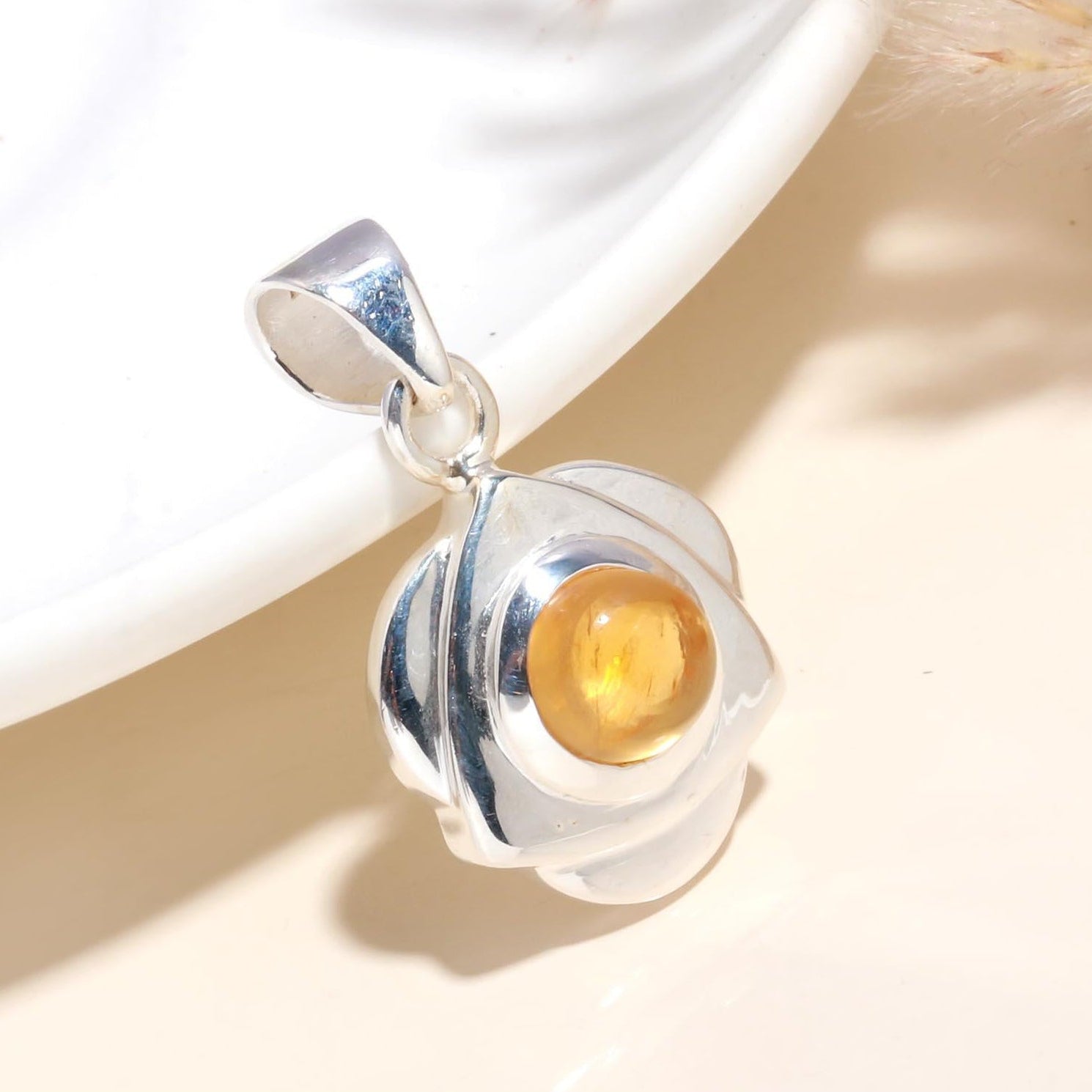 A 925 sterling silver floral pendant with a citrine cabochon, displayed against a light background.