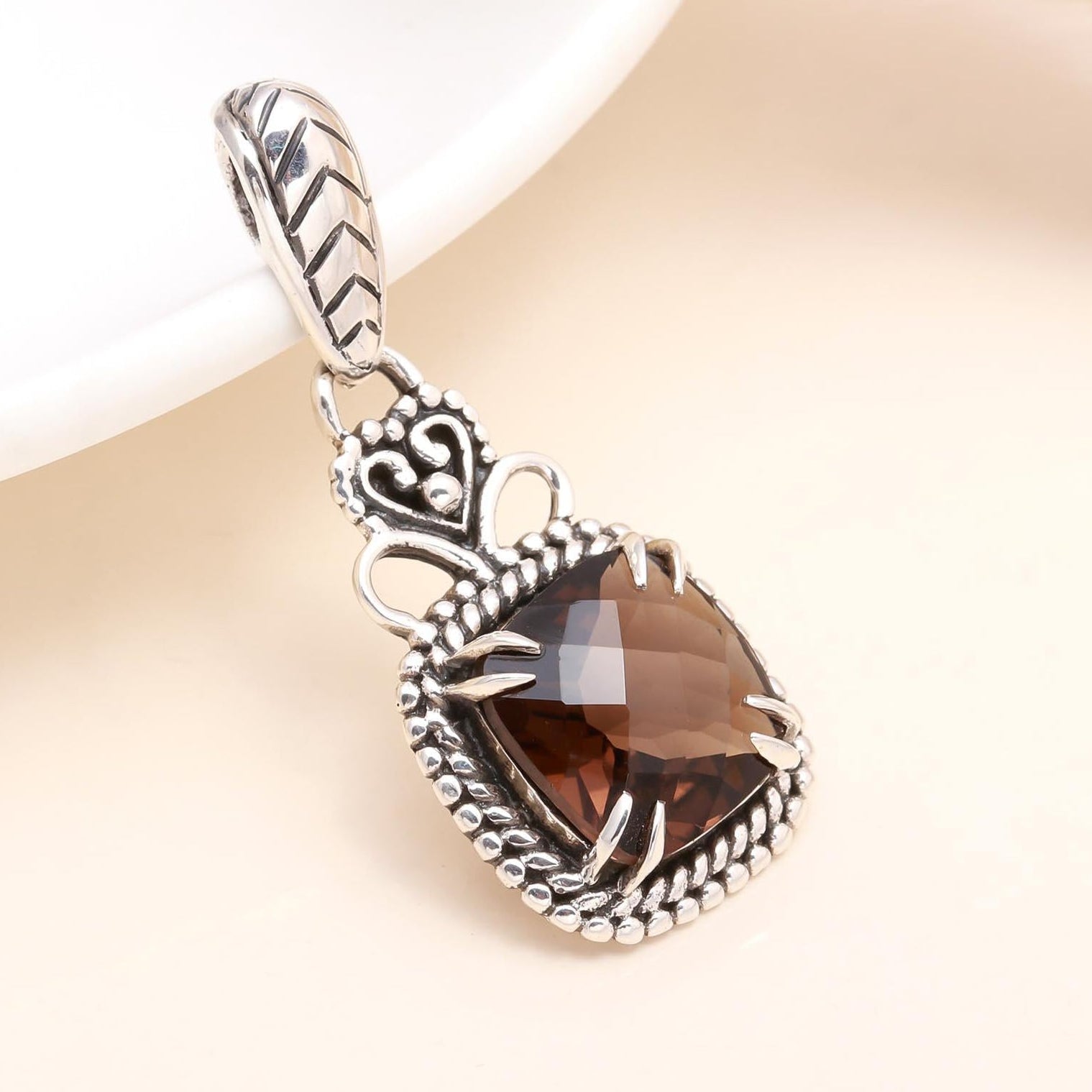 A vintage sterling silver boho pendant featuring a smoky quartz gemstone with intricate detailing.