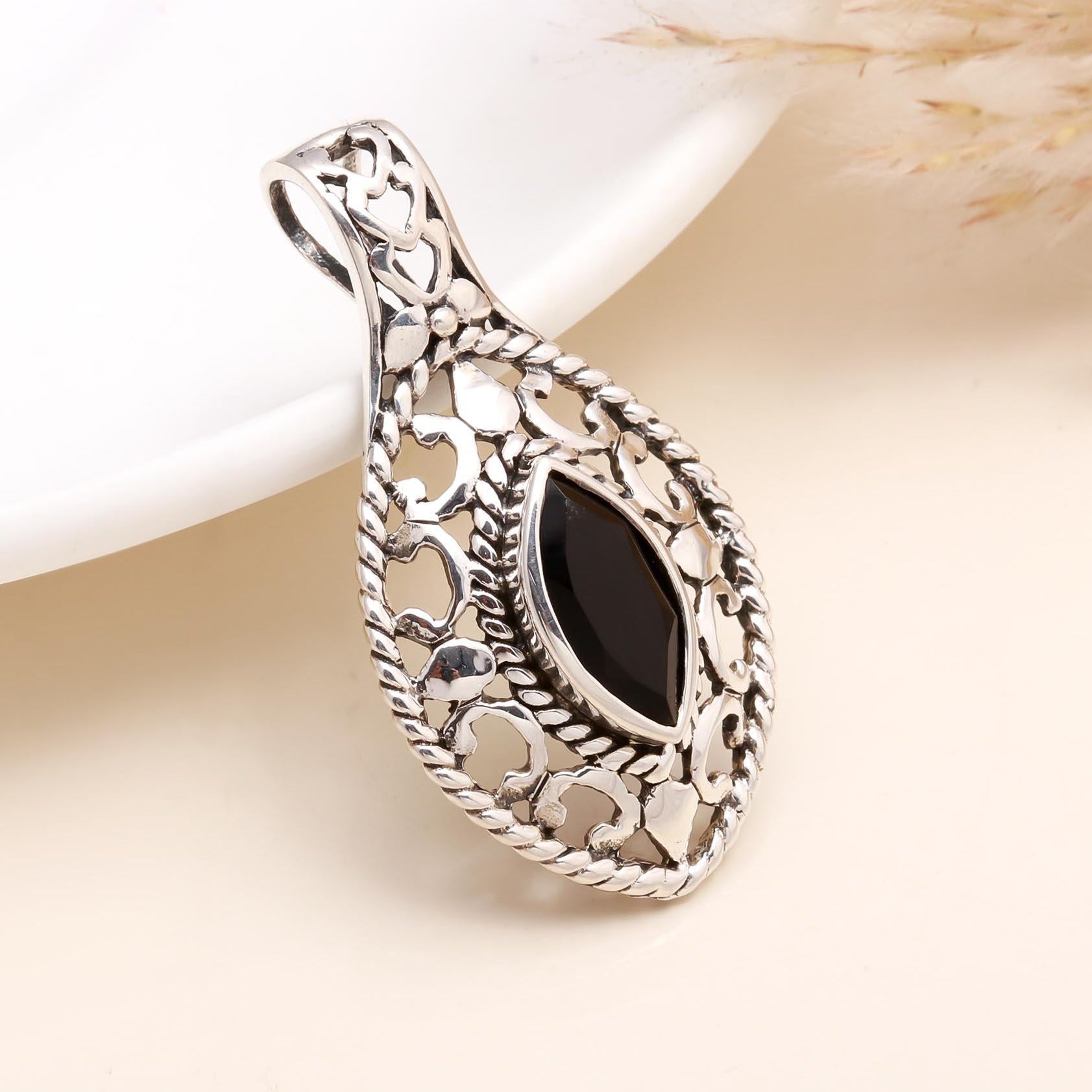 A sterling silver marquise black onyx filigree teardrop pendant on a white background.