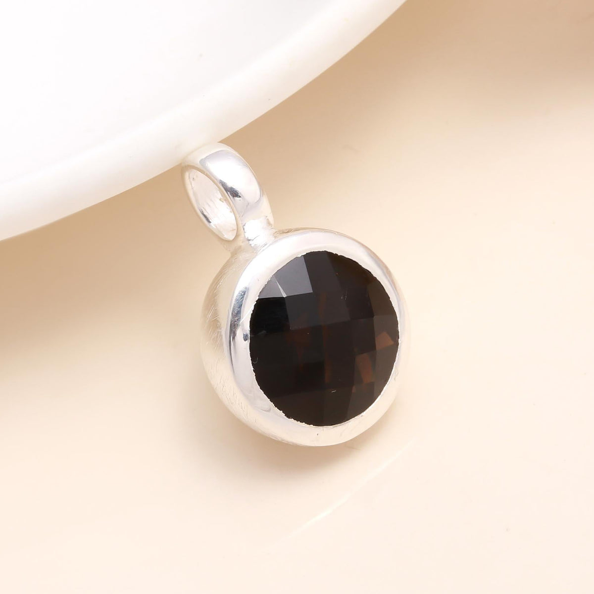 A 925 Sterling Silver Faceted Smoky Quartz Round Pendant with a silver bezel setting on a white background.