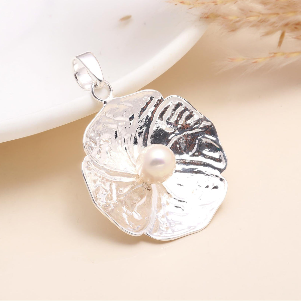 925 Sterling Silver Floral Pendant with a natural white freshwater pearl at the center, displayed against a beige background