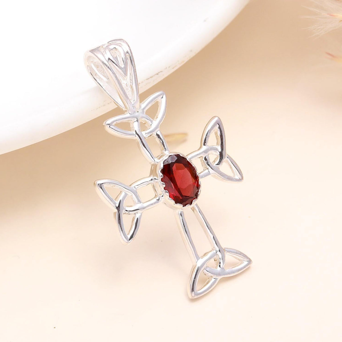 A 925 Sterling Silver Celtic Cross Pendant with a central garnet gemstone, displayed against a neutral background.