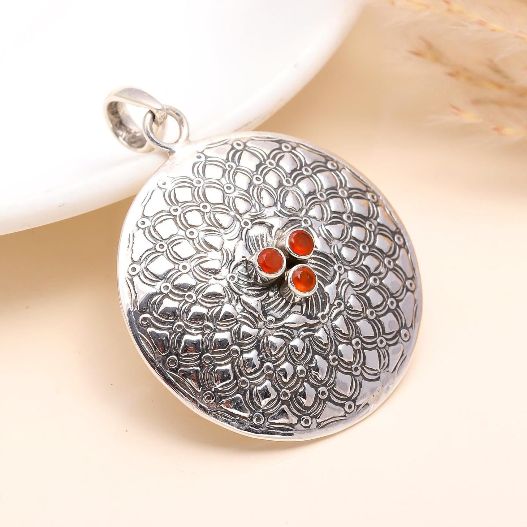 A 925 Sterling Silver Carnelian Medallion Pendant with intricate geometric patterns and three red carnelian stones in the center, displayed against a neutral background.