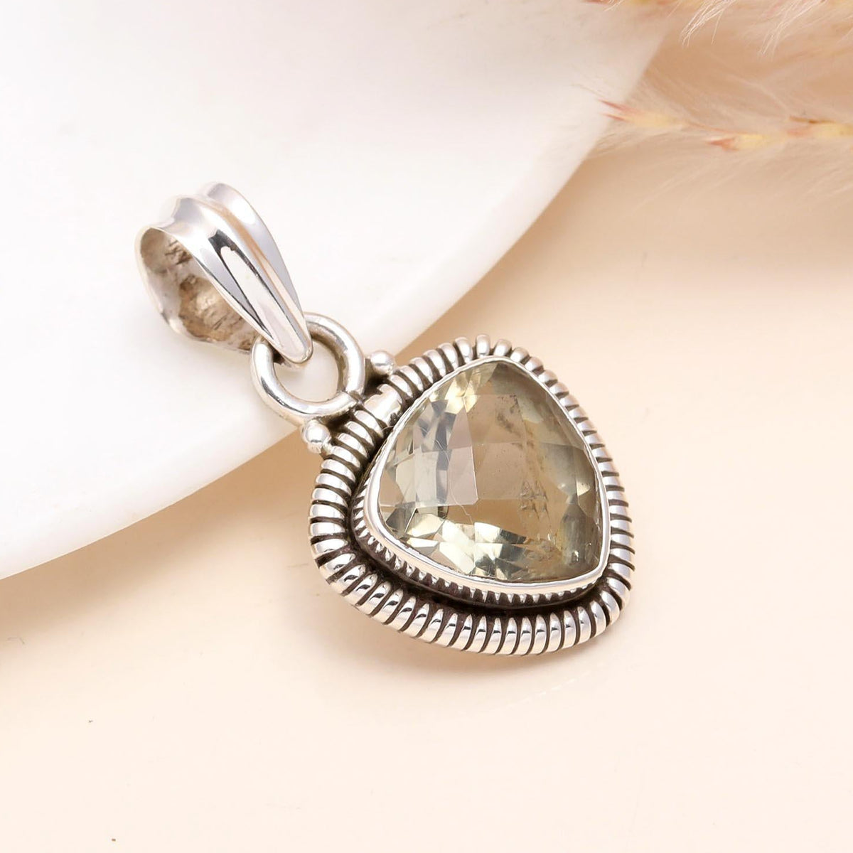 A trillion-cut lemon quartz gemstone pendant set in a sterling silver boho-style setting, displayed against a neutral background.