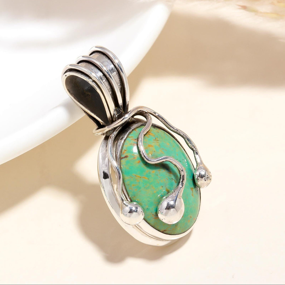 A 925 Sterling Silver pendant with a turquoise gemstone set in a bohemian-style setting, displayed against a neutral background.