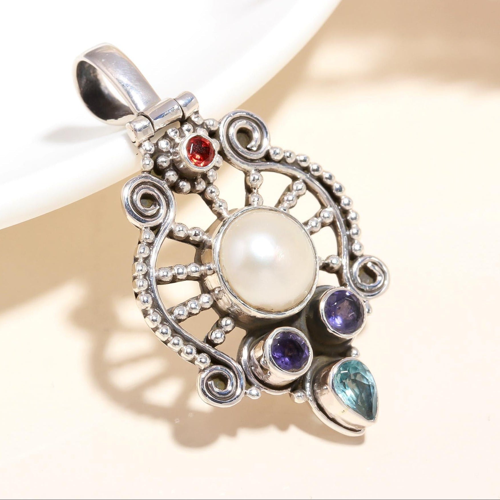 A vintage style 925 sterling silver pendant featuring a natural freshwater pearl and multiple colorful gemstones, with intricate filigree silverwork.