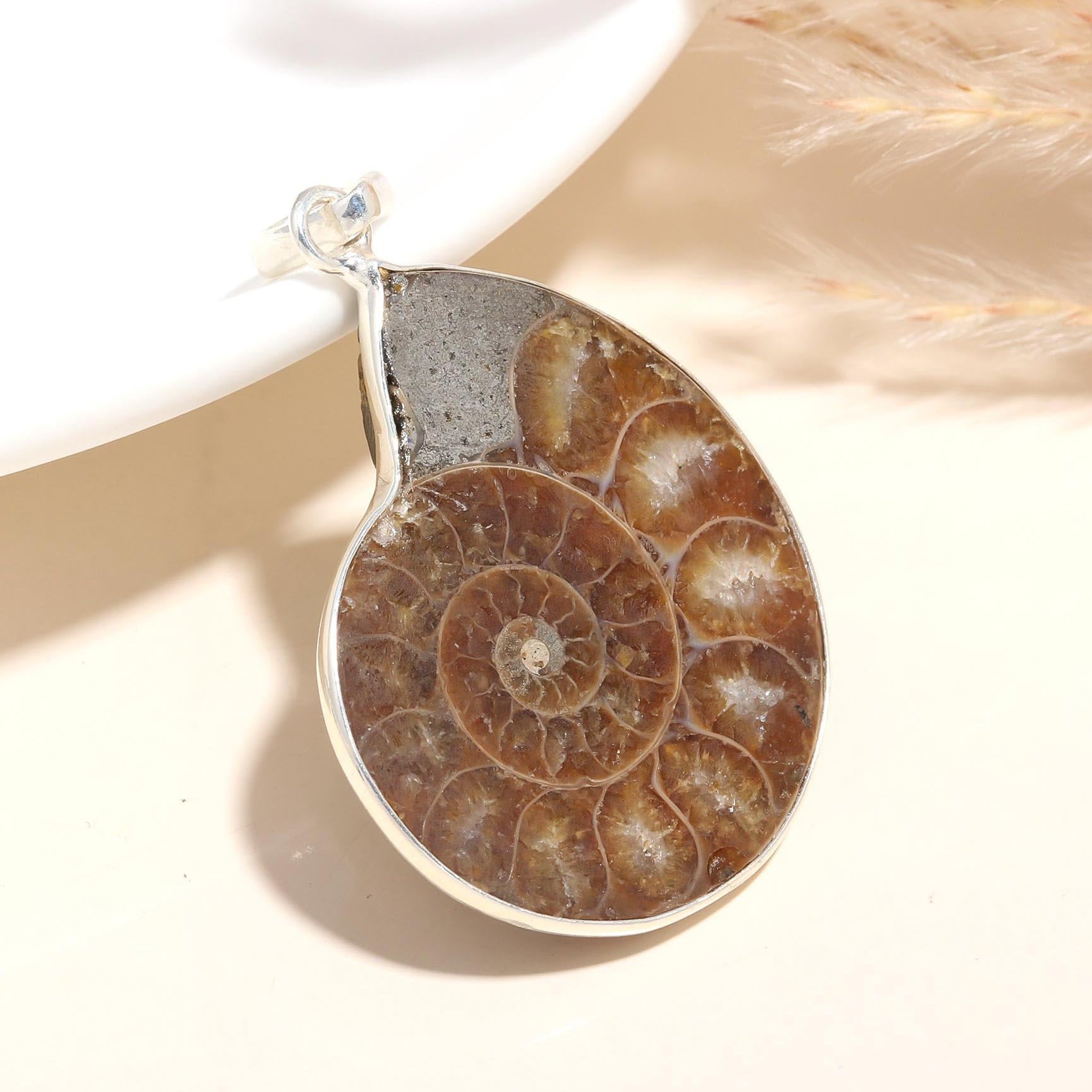 A 925 Sterling Silver pendant featuring a natural spiral shell ammonite fossil, displayed against a neutral background.
