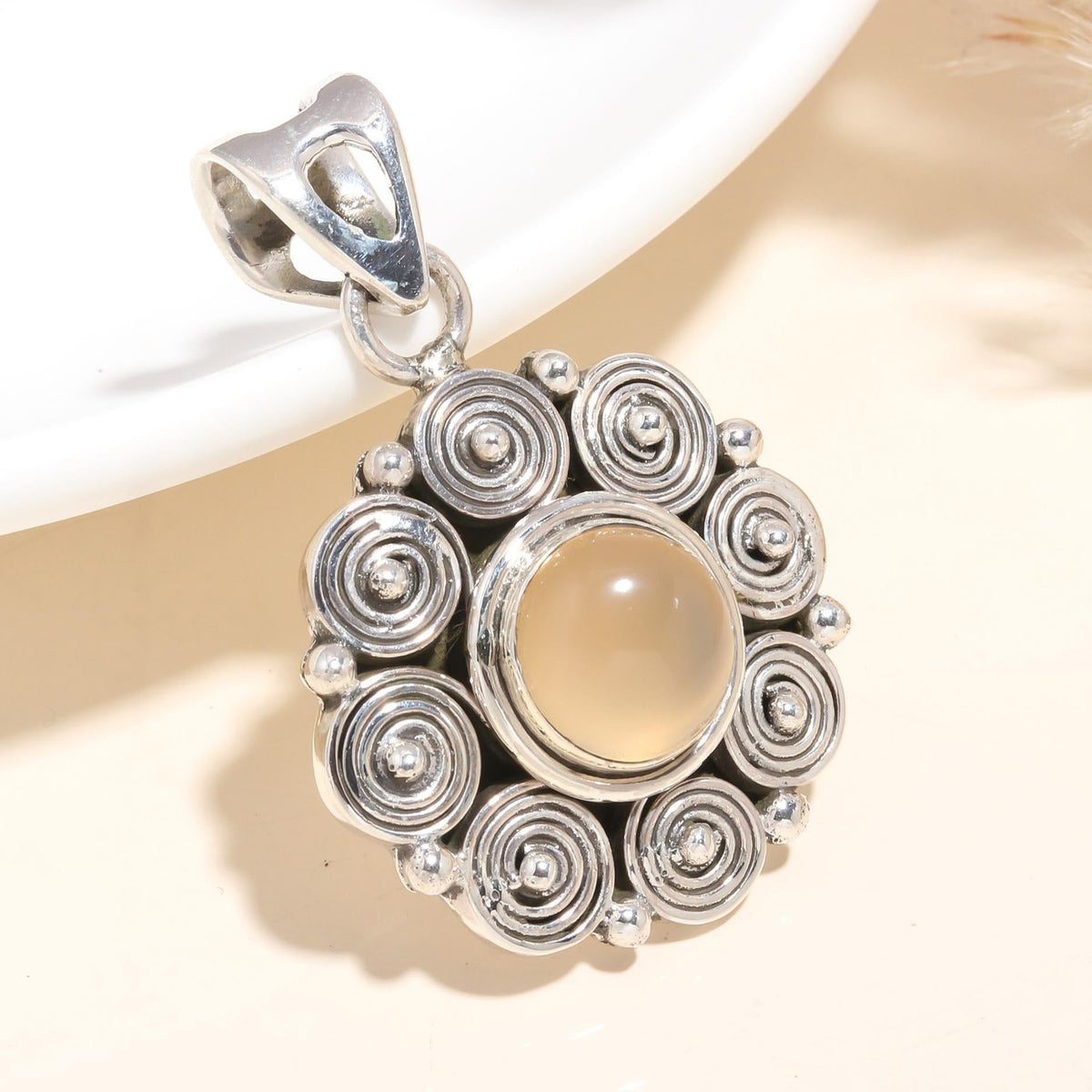 A 925 Sterling Silver pendant featuring a natural moonstone with a handmade swirl design.