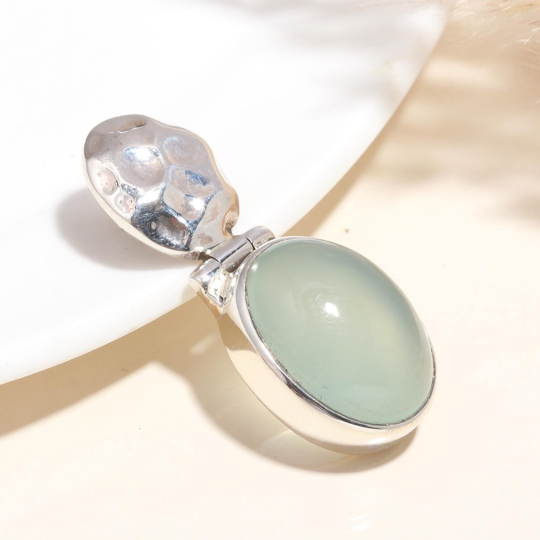 A 925 Sterling Silver pendant with an oval-shaped natural green chalcedony gemstone, featuring handcrafted silverwork.