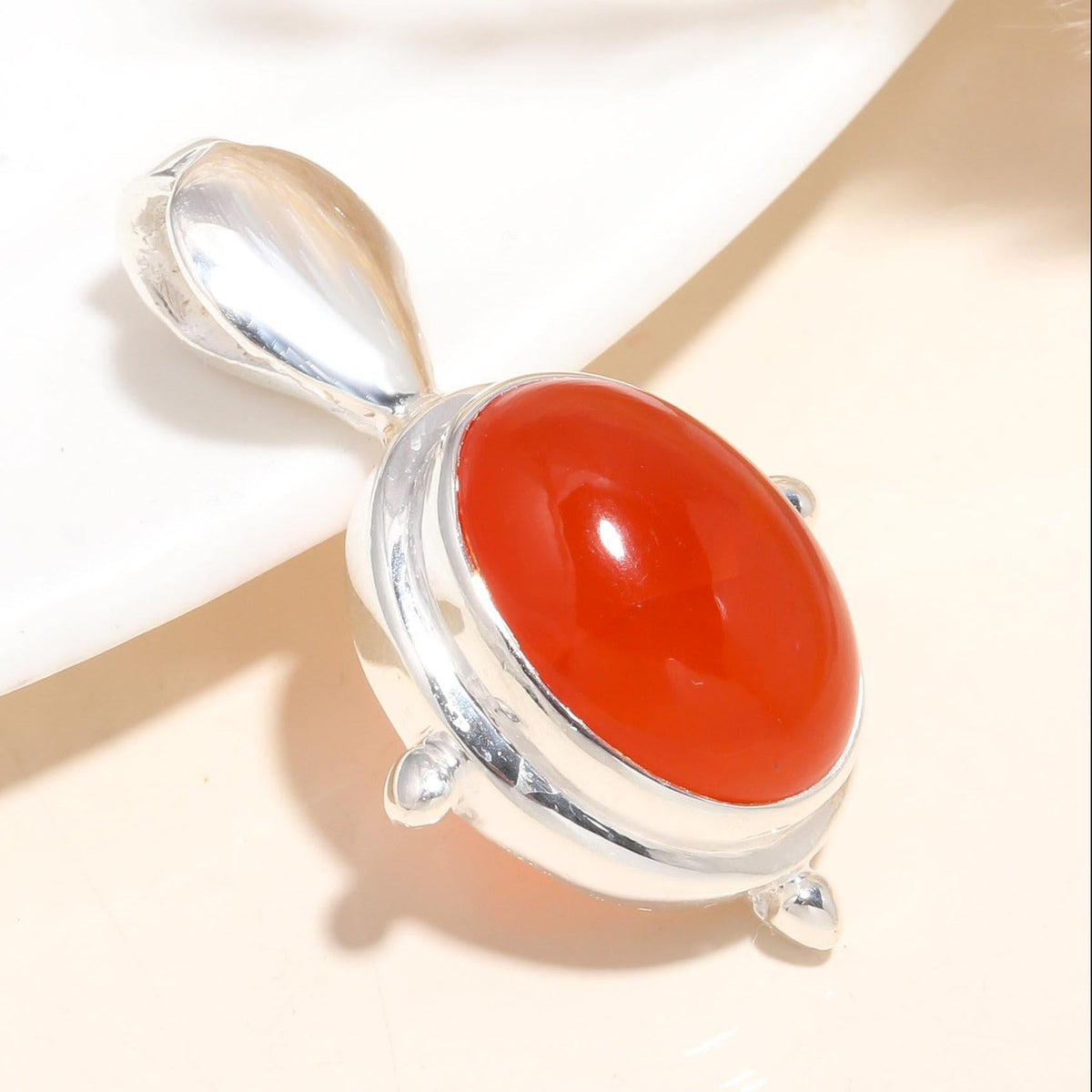 A 925 Sterling Silver pendant with a large, oval-shaped red carnelian gemstone, featuring handcrafted artisan detailing.