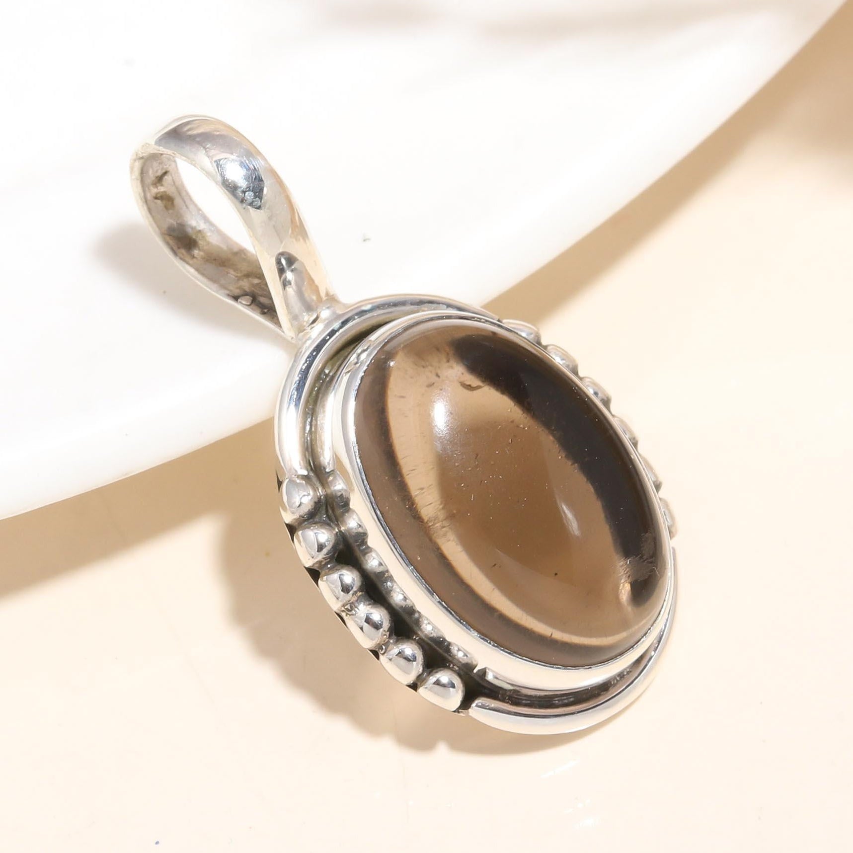 A 925 sterling silver pendant featuring a natural smoky quartz gemstone, with intricate artisan detailing.