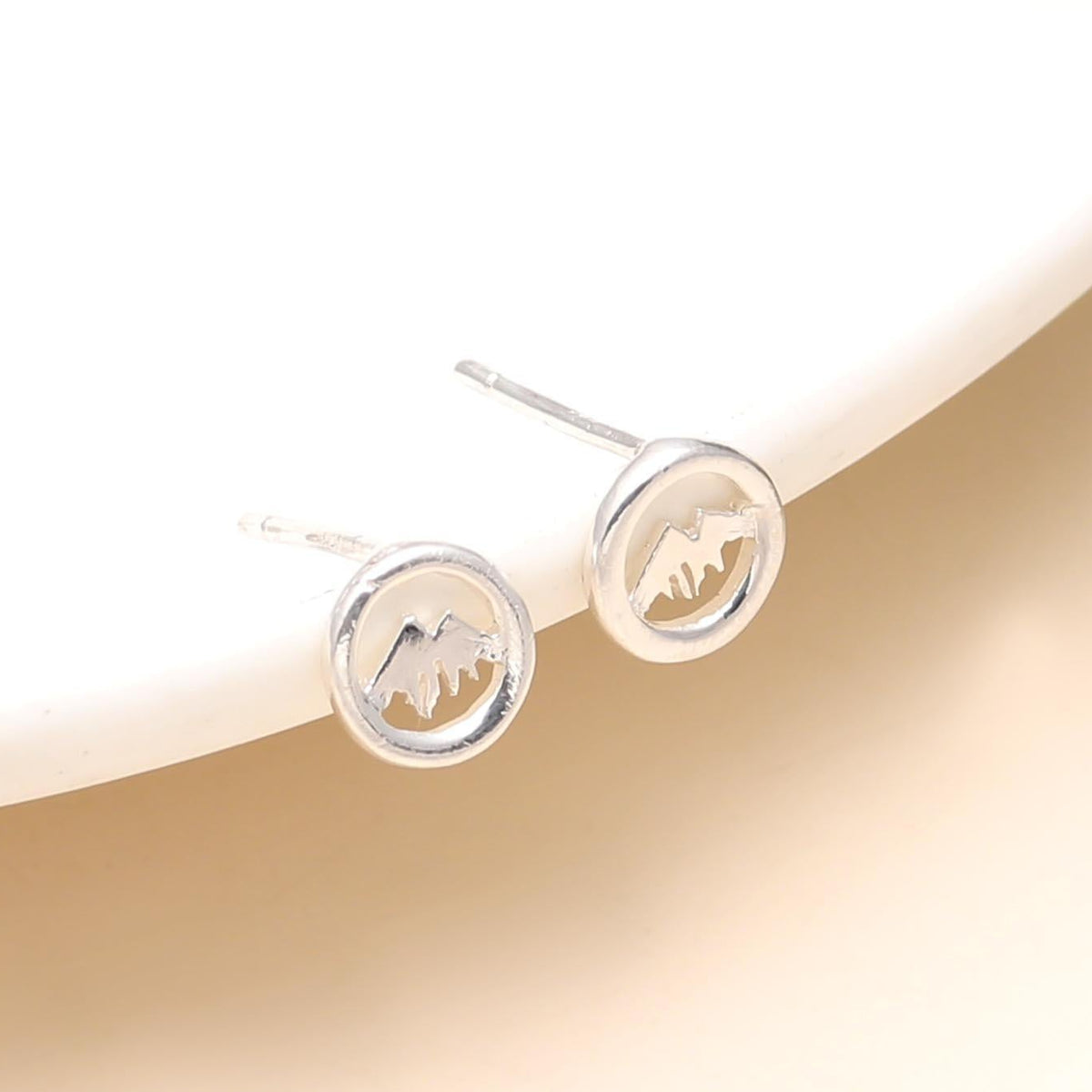 A pair of 925 sterling silver stud earrings with a tree design, displayed on a white surface.