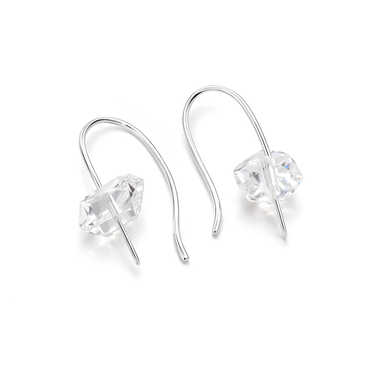 Silver earrings with clear gemstones on a white background