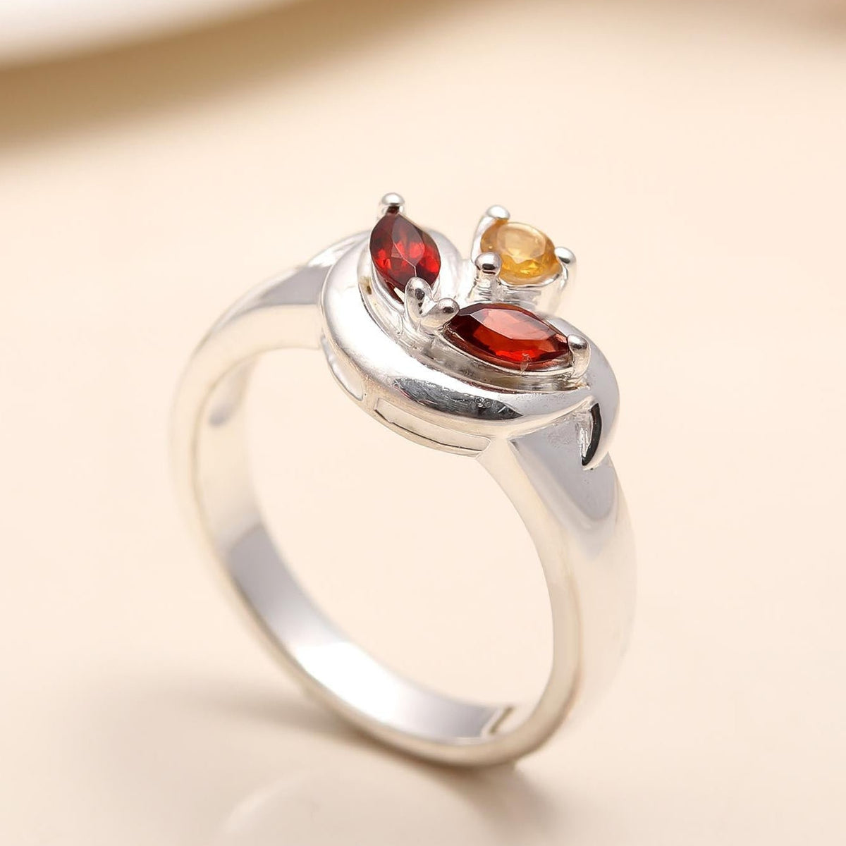 Side view showing the sleek silver band of the garnet ring.