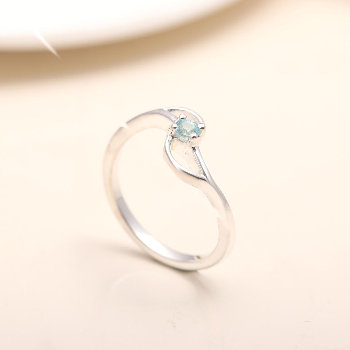 Modern sterling silver twist band ring with blue topaz