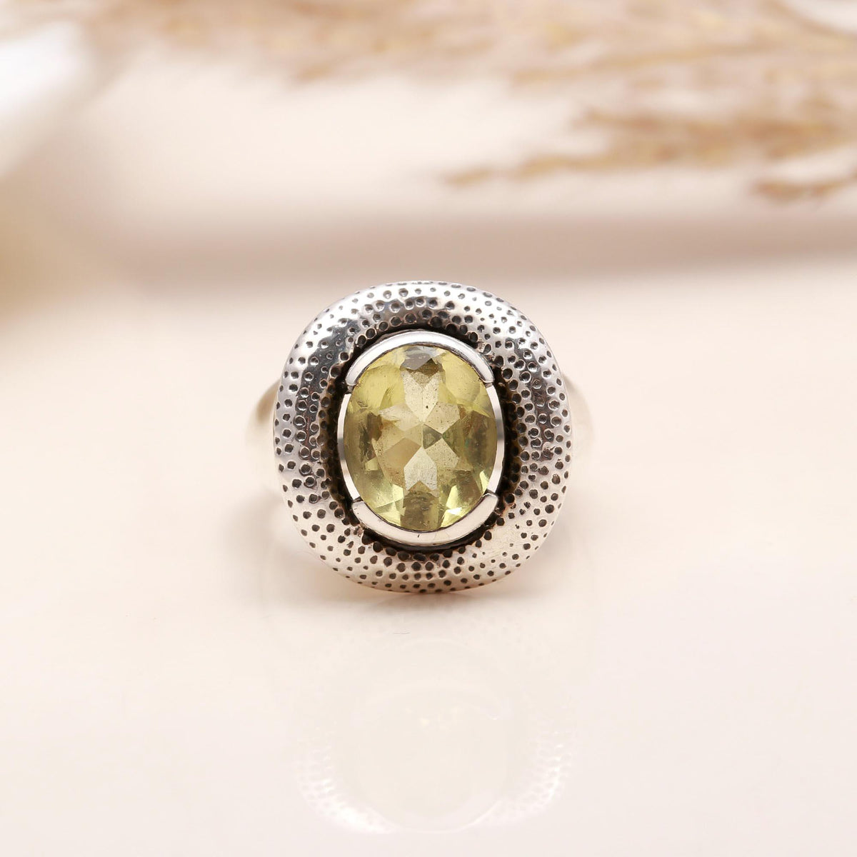 Close-up of oval lemon quartz textured silver band ring