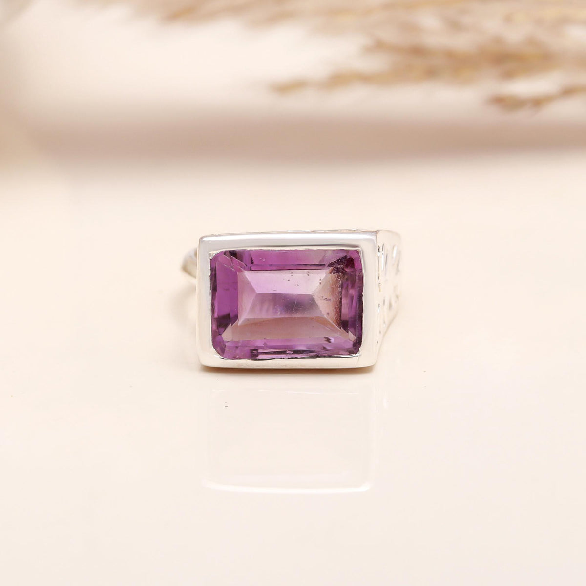 Faceted emerald-cut amethyst solitaire silver ring close-up