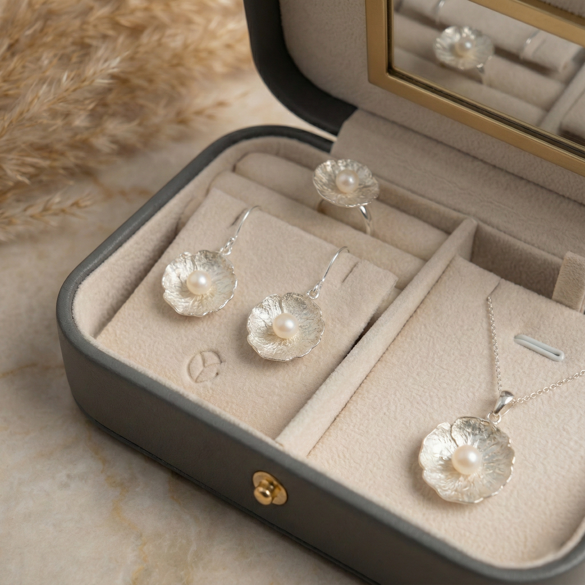 Jewelry set with pearl earrings and necklace in an open jewelry box.