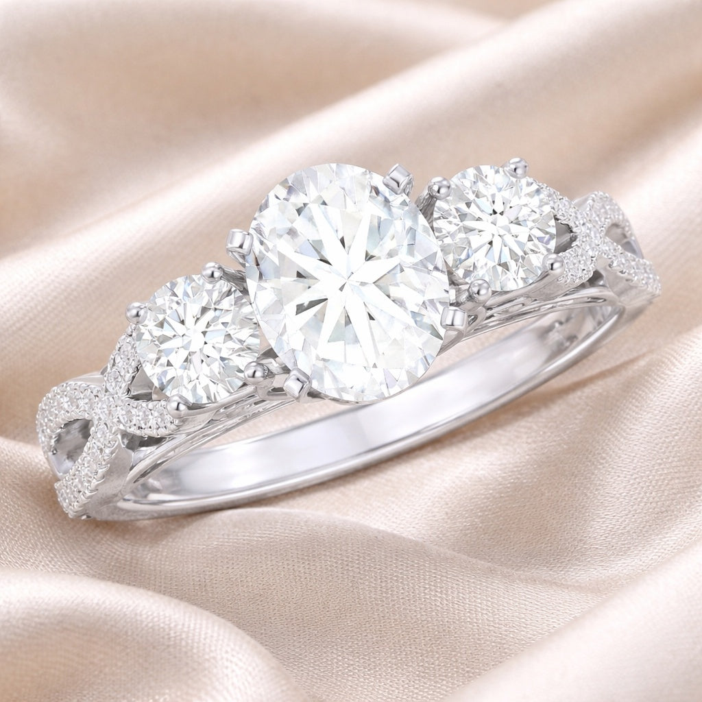 Diamond ring with three round stones on a soft pink fabric background